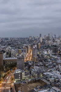 Aerial view of buildings in city against sky