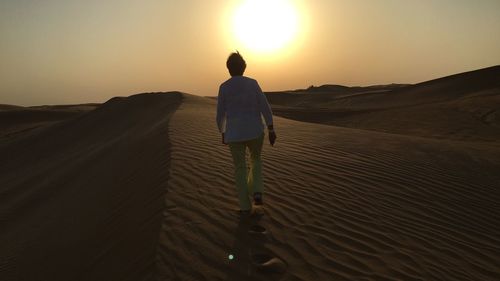 Rear view of man on sand dune