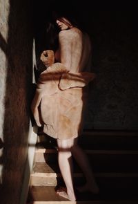 Full length of woman standing on staircase