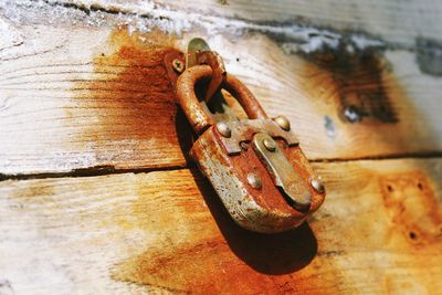 Close-up of rusty padlock on wood