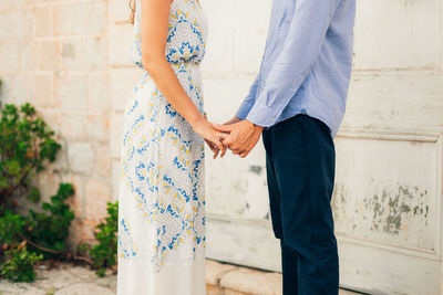 Midsection of couple standing in sunlight