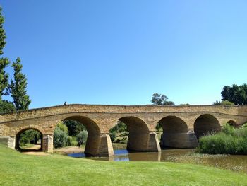 Arch bridge against clear blue sky