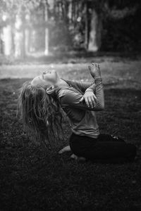 Rear view of woman sitting on field