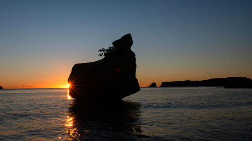 Silhouette boat in sea against sky during sunset