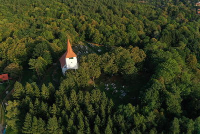 Flying above old whitewashed reformed church and cemetery aerial. medieval landmark, romania