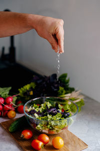 Cropped hand of person preparing food on table