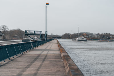 Bridge over river against sky in city