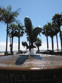 View of statue by swimming pool against sky
