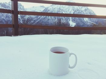 Close-up of coffee cup in snow