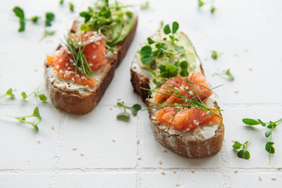 Sandwiches with salted salmon, avocado and microgreens. healthy food.