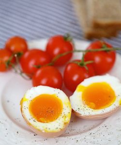 Close-up of boiled eggs with fresh cherry tomatoes in plate