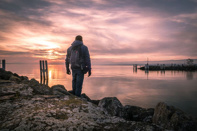 Rear view of man looking at sea against sky