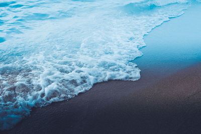 High angle view of waves rushing towards shore