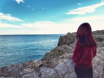 Rear view of woman looking at sea against sky