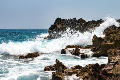 Scenic view of rocks in sea against sky