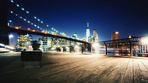 Illuminated brooklyn bridge by city against clear sky at night