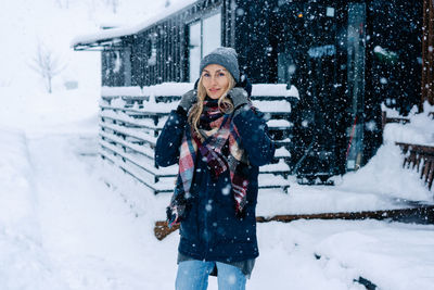 Young beautiful woman in a coat and hat on a winter snowy day.