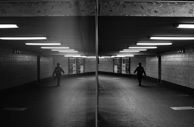 Reflection of person walking in subway station on glass