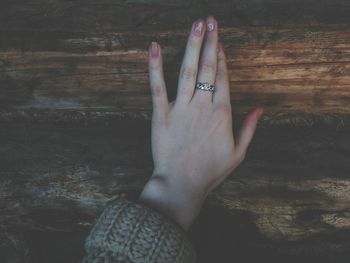 Cropped hand of woman on wooden table