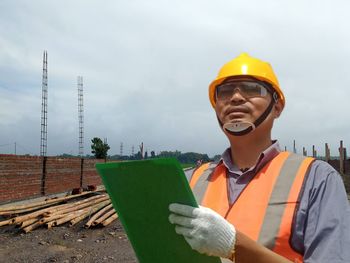 Man working at construction site against sky