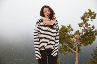Portrait of young woman wearing striped top during foggy weather