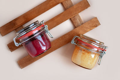 Transparent glass jars with raspberry, blueberry, and ginger honey on a wooden palette. natural food 