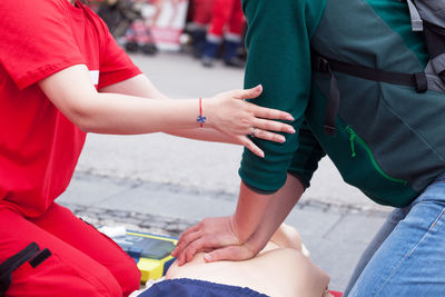 Midsection of women giving cpr on dummy
