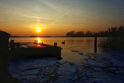 Scenic view of lake against sky during sunset