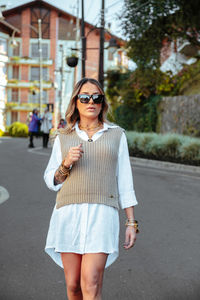 Young woman wearing sunglasses standing on road