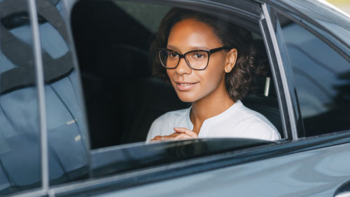 Portrait of woman sitting in car window