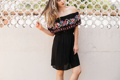 Midsection of woman standing against wall