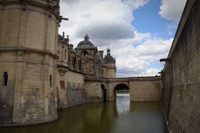 Arch bridge over river against sky