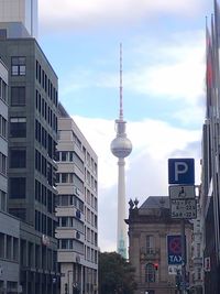 View of communications tower in city against sky