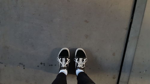 Low section of person standing on concrete floor