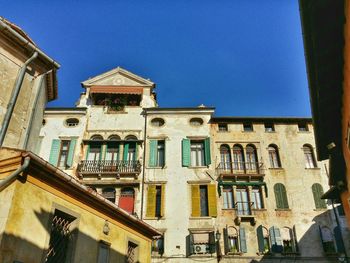 Low angle view of buildings against clear blue sky