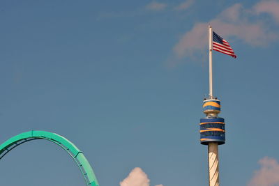 Low angle view of amusement park ride against blue sky