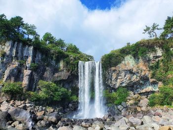 Scenic view of waterfall against sky