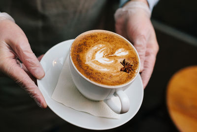 Midsection of man holding coffee cup