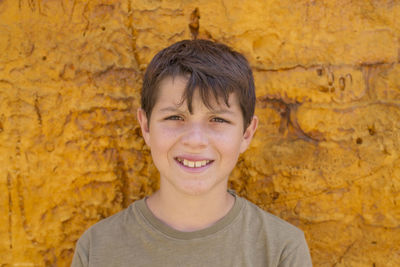 Portrait of teenage boy standing by wall
