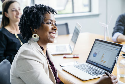 Smiling businesswomen with colleagues in office