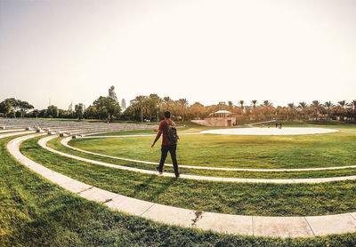 Man standing on golf course against clear sky