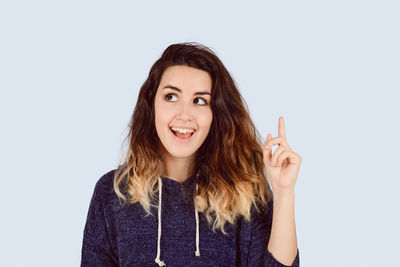 Smiling young woman looking away against white background