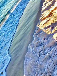 Close-up of wave on beach against blue sky