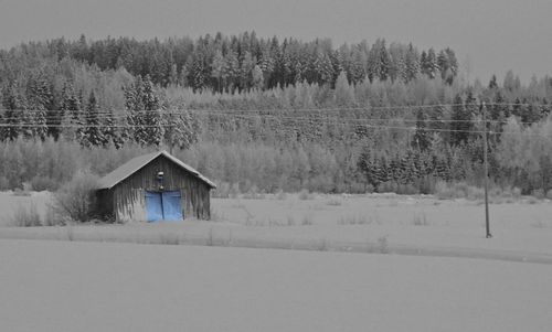 Built structure on snow field against sky
