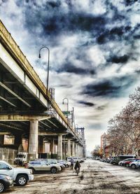 Cars parked against cloudy sky