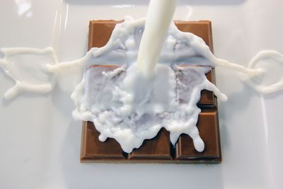 High angle view of milk pouring on chocolate