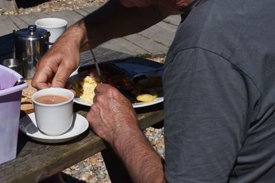 Midsection of man holding coffee cup