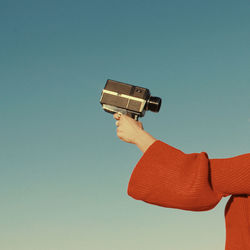 Man photographing against blue sky