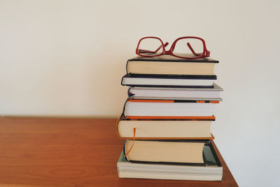 Close-up of books on table against wall