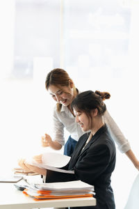 High angle view of mother and daughter sitting on table